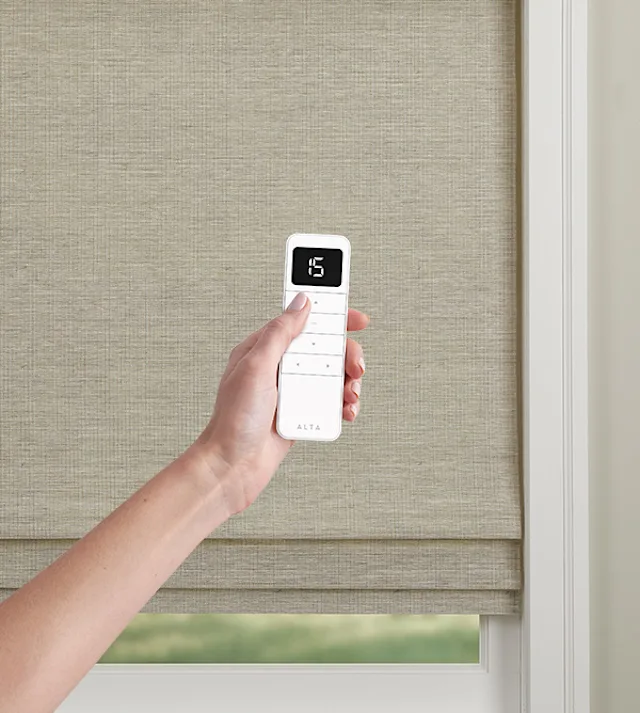 BLISS Automation system for motorized window shades, featuring wirefree rechargeable motors, displayed in a Nicholasville, KY showroom with sleek wooden accents and soft spotlighting.