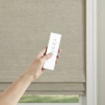 Somfy Automation system for motorized window coverings, featuring quiet motors and designer controls, showcased in a Nicholasville, KY showroom with sleek wooden accents and soft spotlighting.